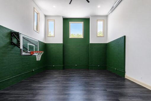 Apex indoor basketball court with green walls and high windows