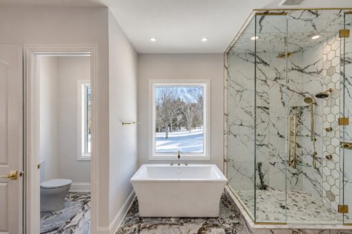 Apex primary bath freestanding tub and marble shower with gold fixtures