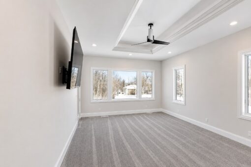Apex primary bedroom with tray ceiling and windows