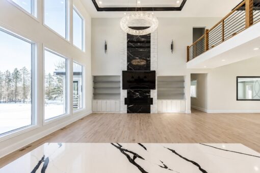 Apex two-story great room with black marble fireplace and ring chandelier