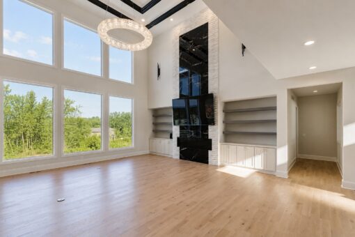 Apex two-story great room with black marble fireplace and window wall