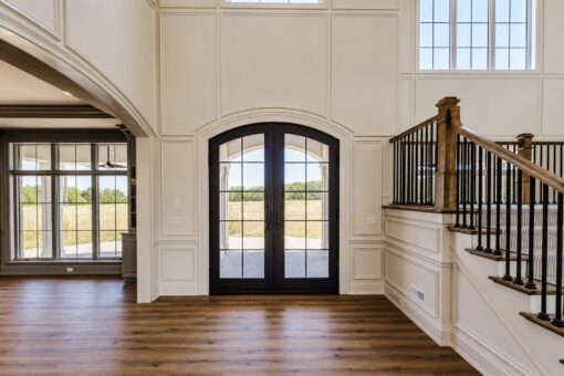 Ridge arched iron double doors beside the staircase
