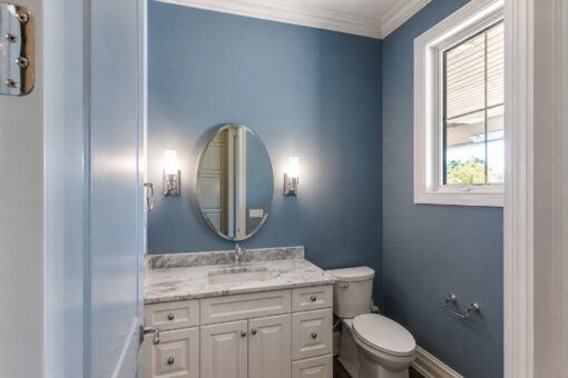 Ridge bathroom with blue walls and oval mirror
