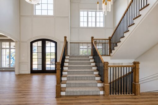 Ridge foyer staircase with carpet runner and arched entry doors