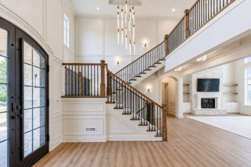 Ridge foyer with arched iron entry door and staircase