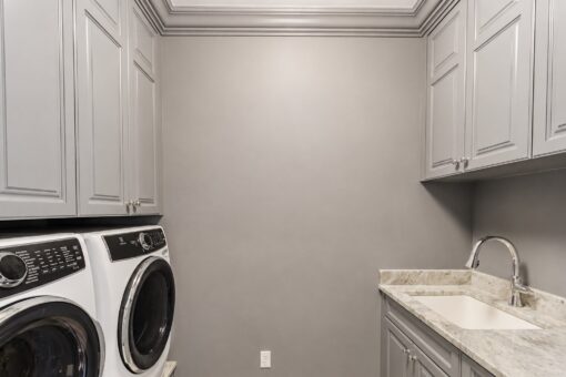 Ridge laundry room with gray cabinetry and utility sink