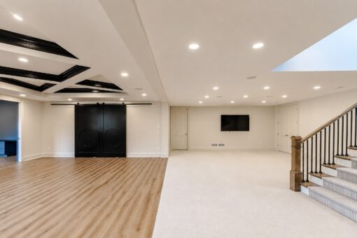 Ridge lower-level family room with barn doors and staircase