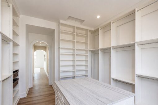 Ridge primary closet with marble island and arched doorway