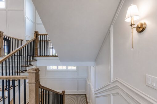 Ridge stair landing with sconce and paneled walls